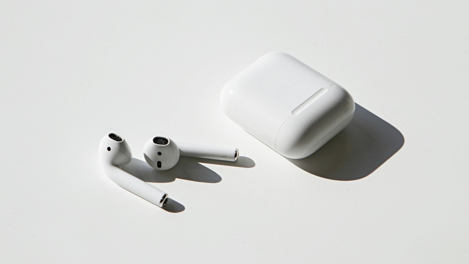 apple earpods beside apple airpods