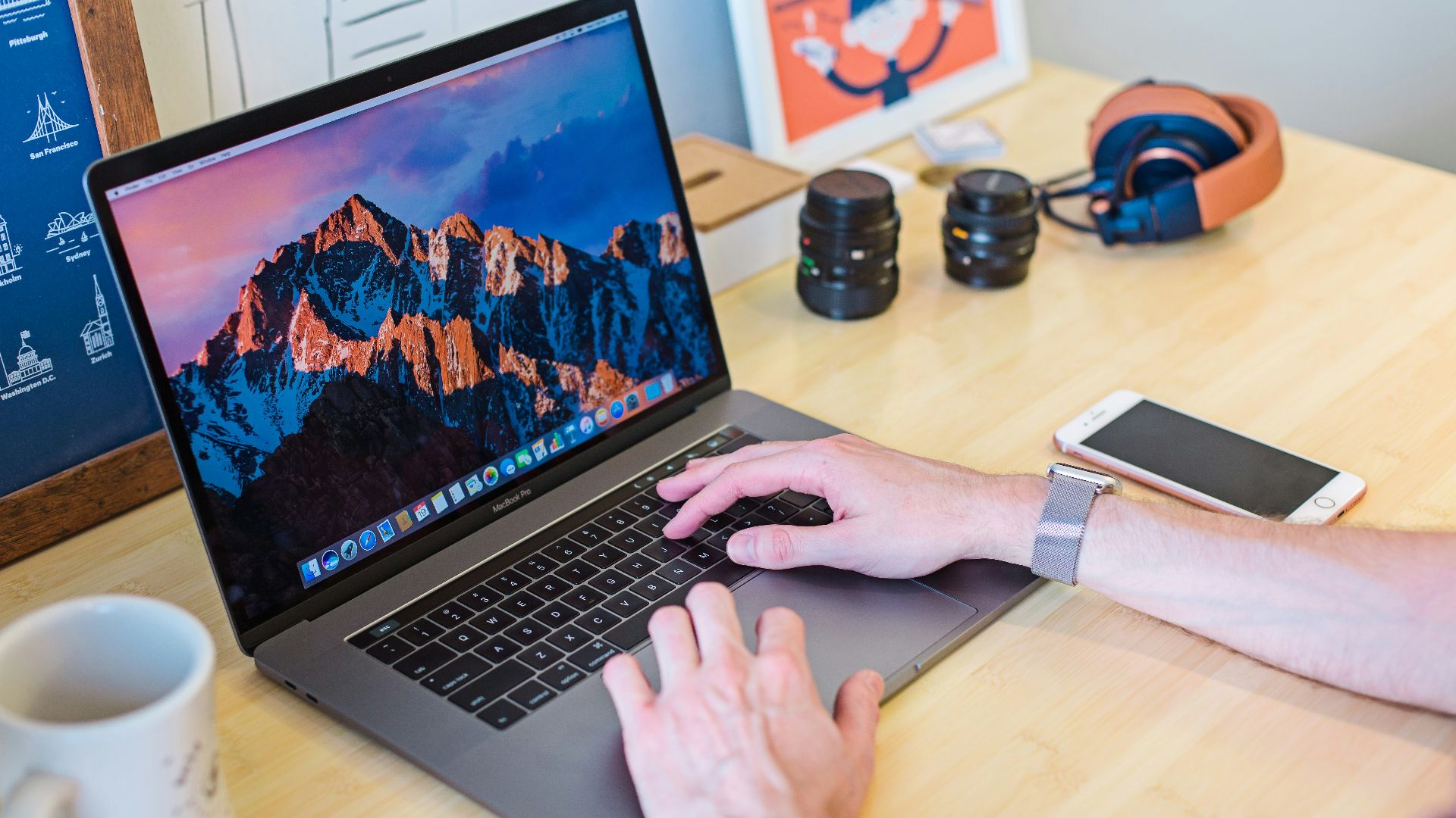 MacBook Pro turned on beside white ceramic mug