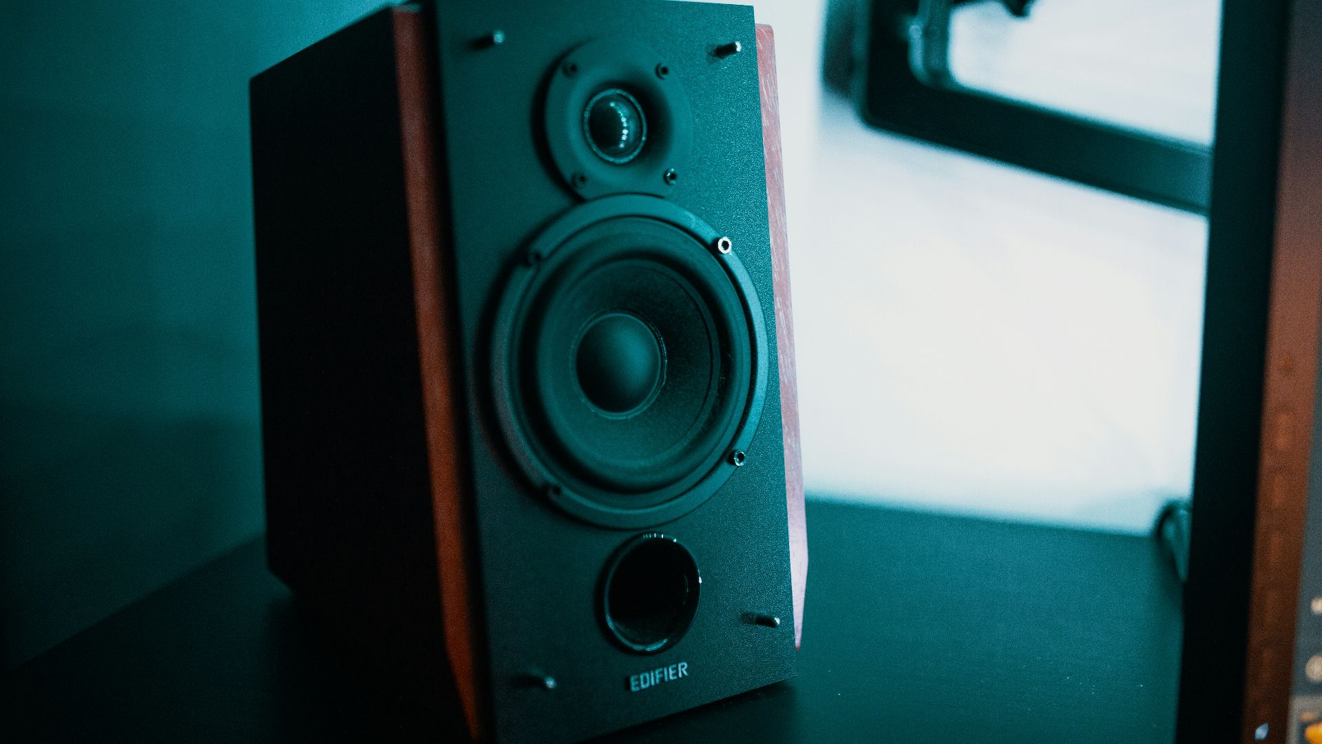 black and brown bookshelf speaker on black surface