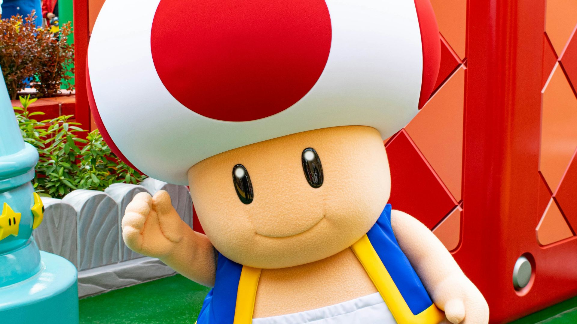 boy in blue and white shirt holding red and white balloon