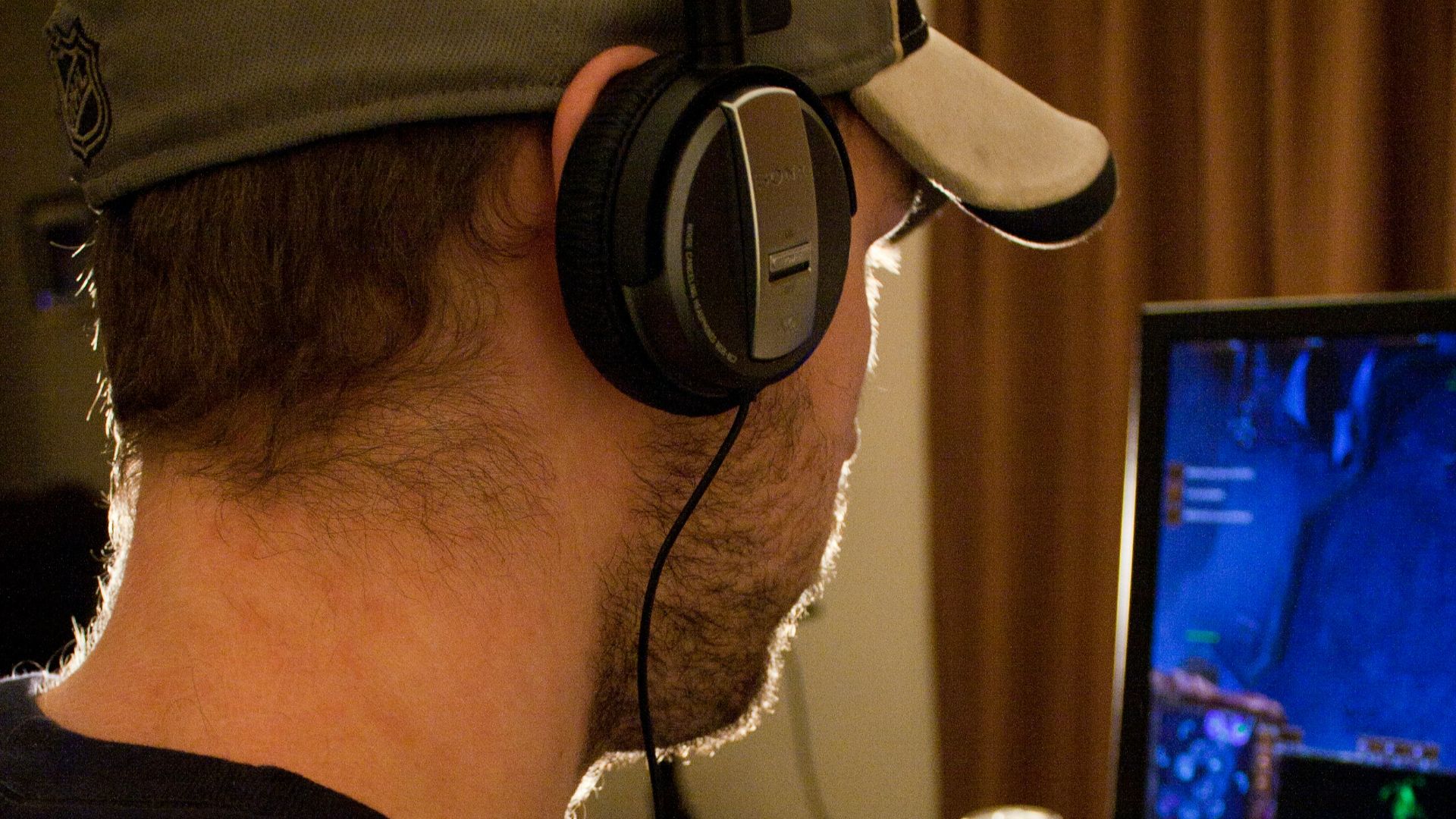 a man sitting in front of a computer with headphones on
