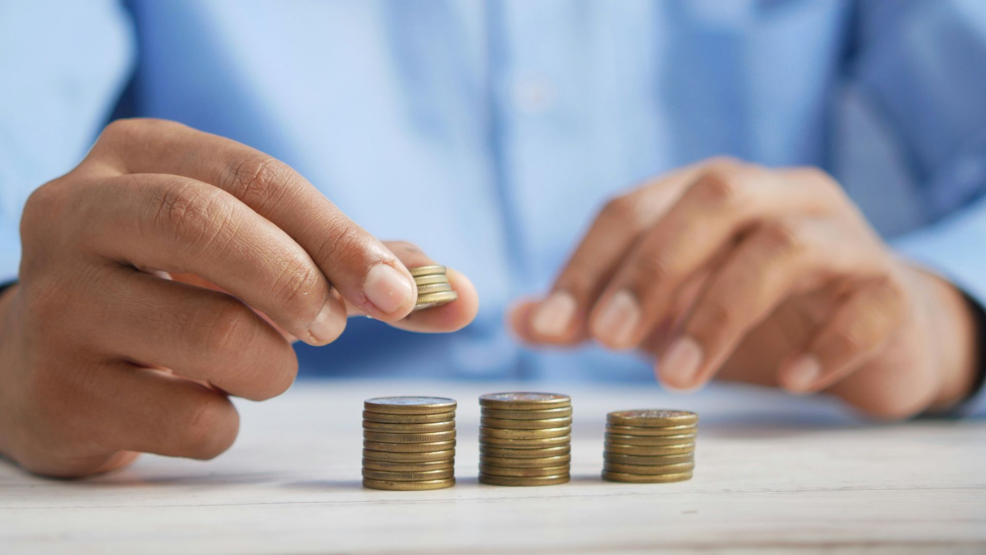 a person stacking coins on top of a table