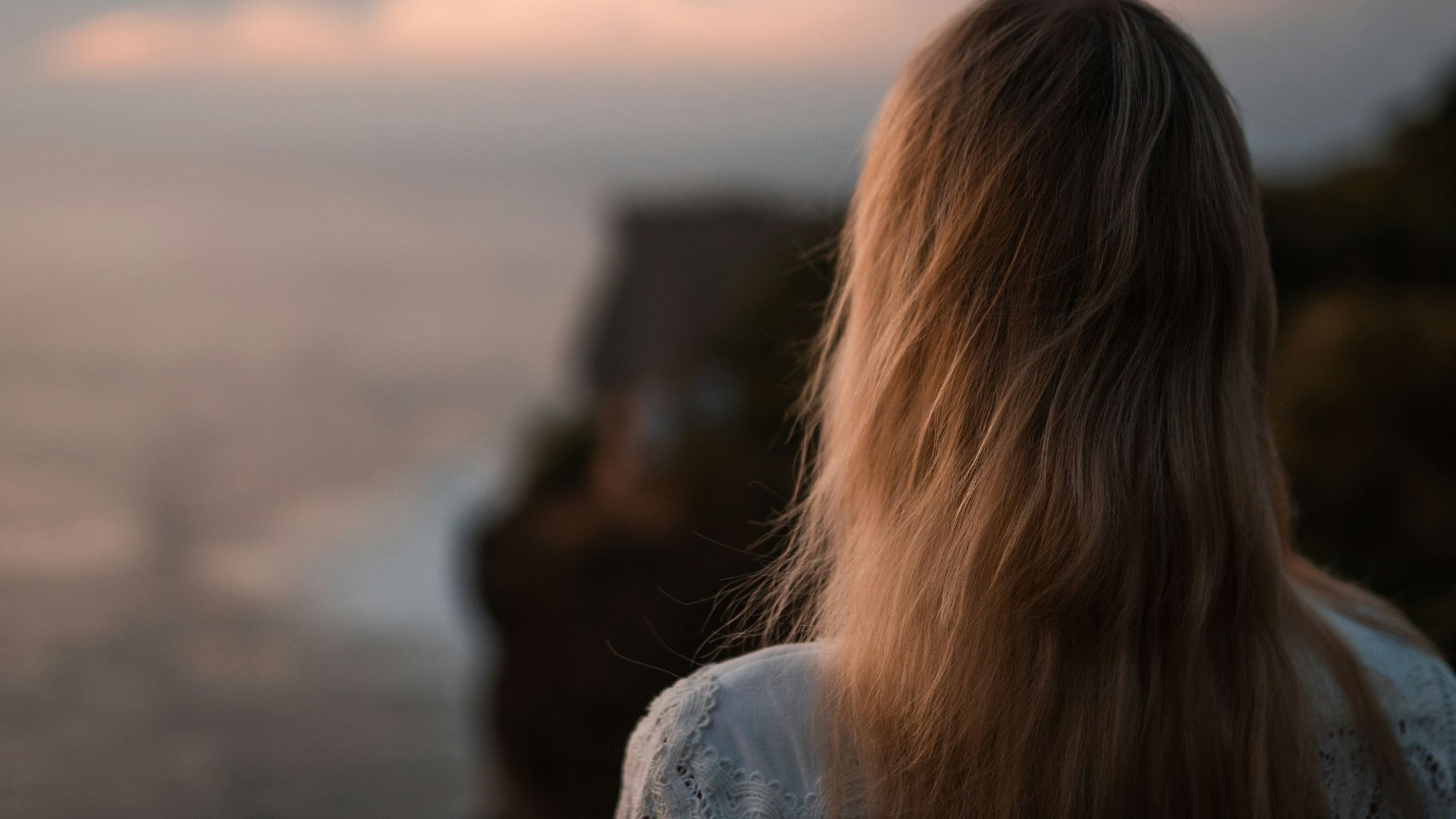 a woman looking at a sunset