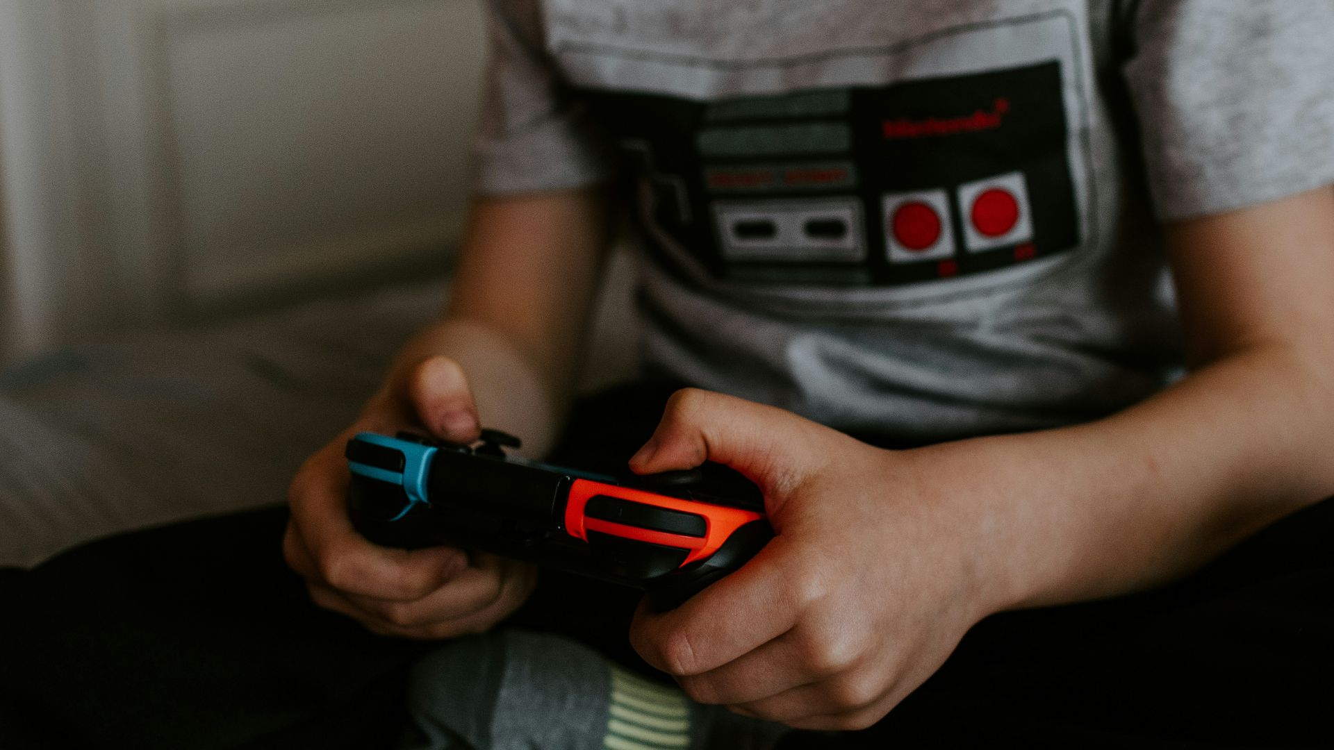 kid sitting on gray bed while playing