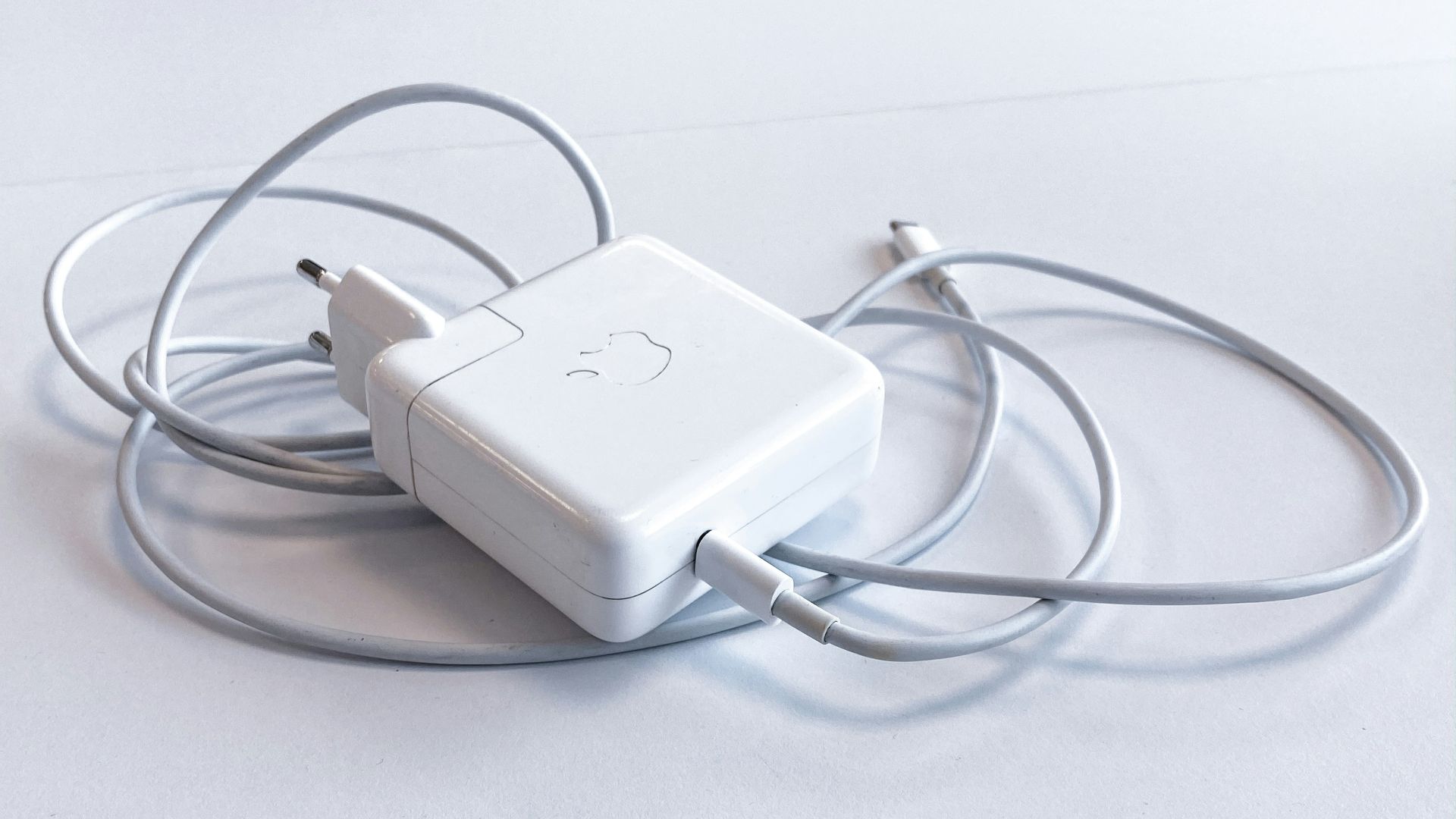 white apple charging adapter on white table