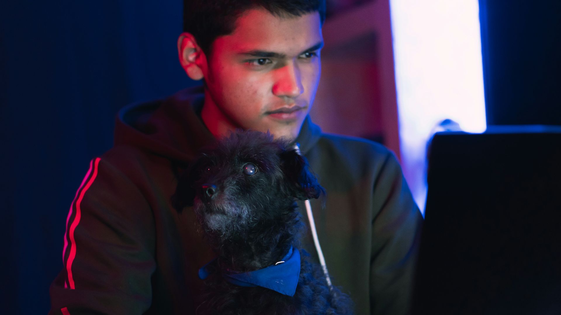 man in brown coat holding black long coat small dog