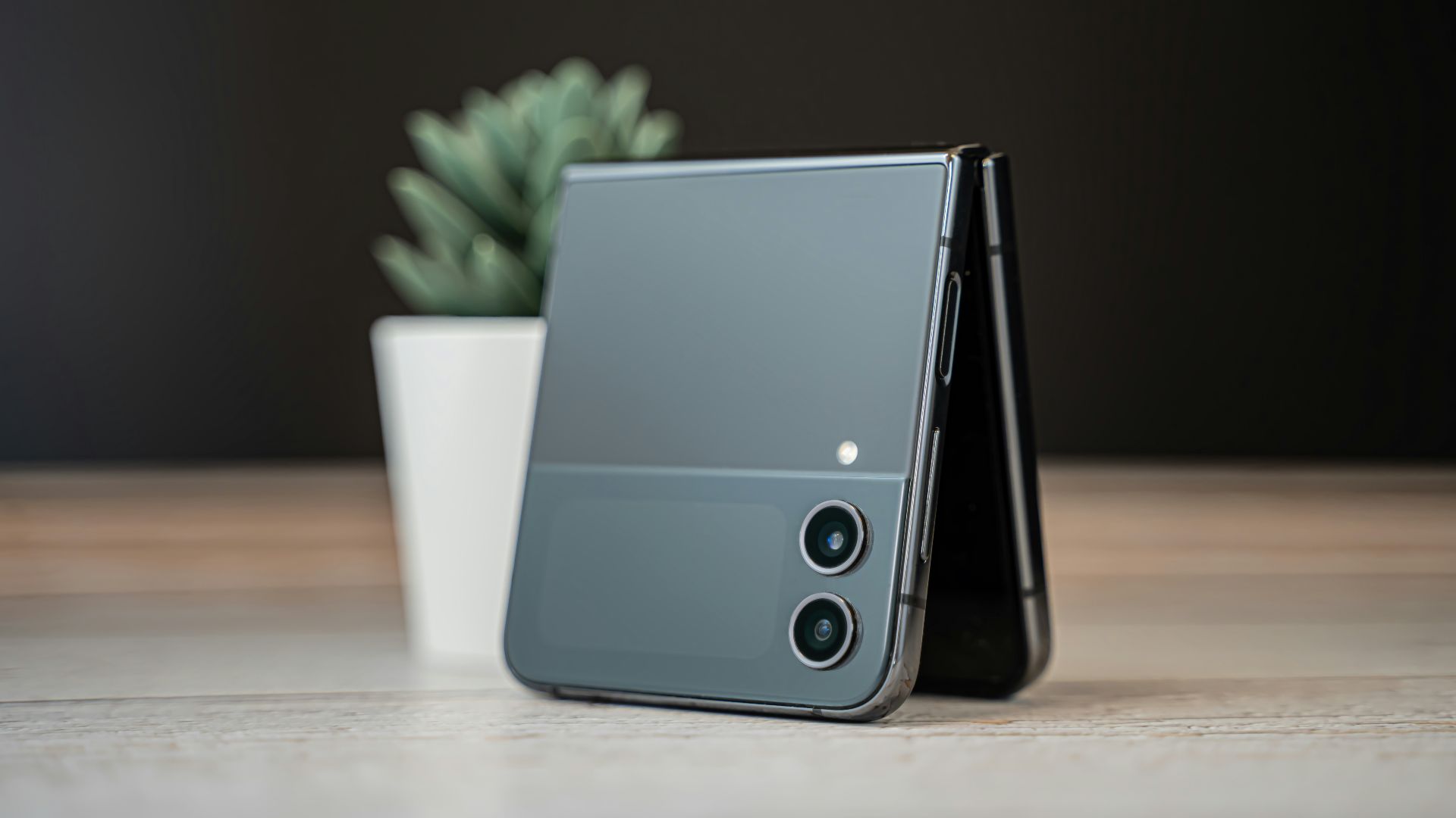 a cell phone sitting on top of a table next to a potted plant