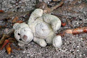 6287248-old-stuffed-teddy-bear-laying-on-ground-300x200.jpg