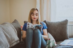 woman-sitting-on-couch-while-reading-a-book-1454906-300x200.jpg