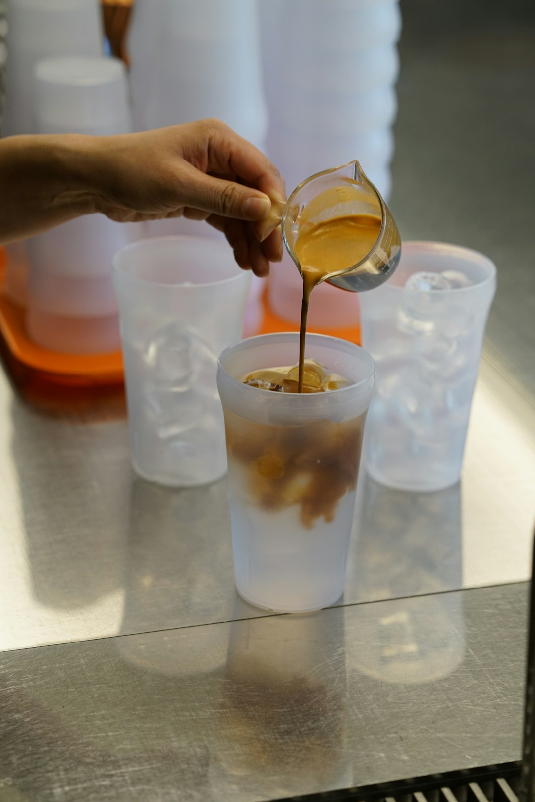 a person is pouring something into a cup