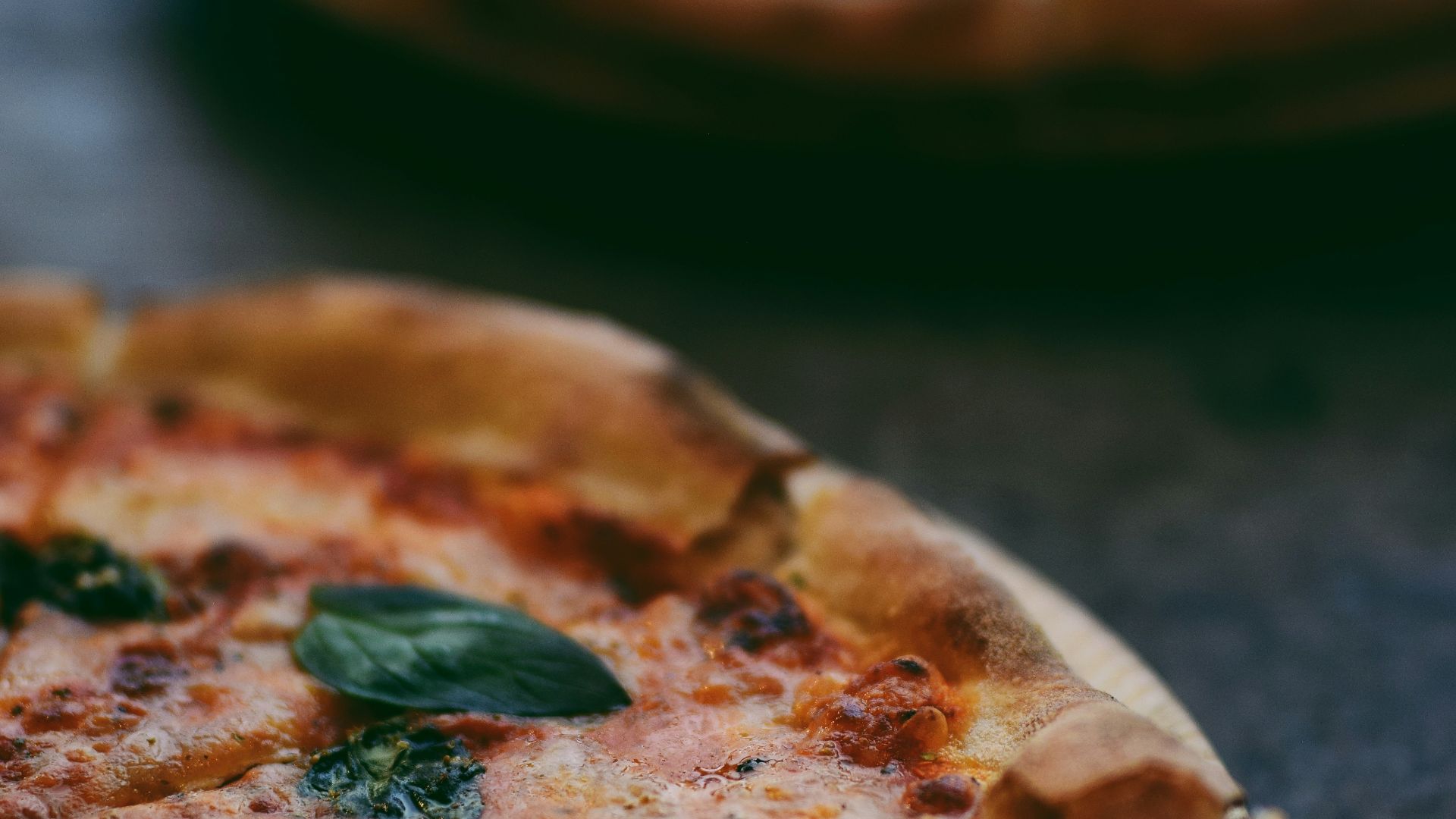 selective focus photography of two pizzas