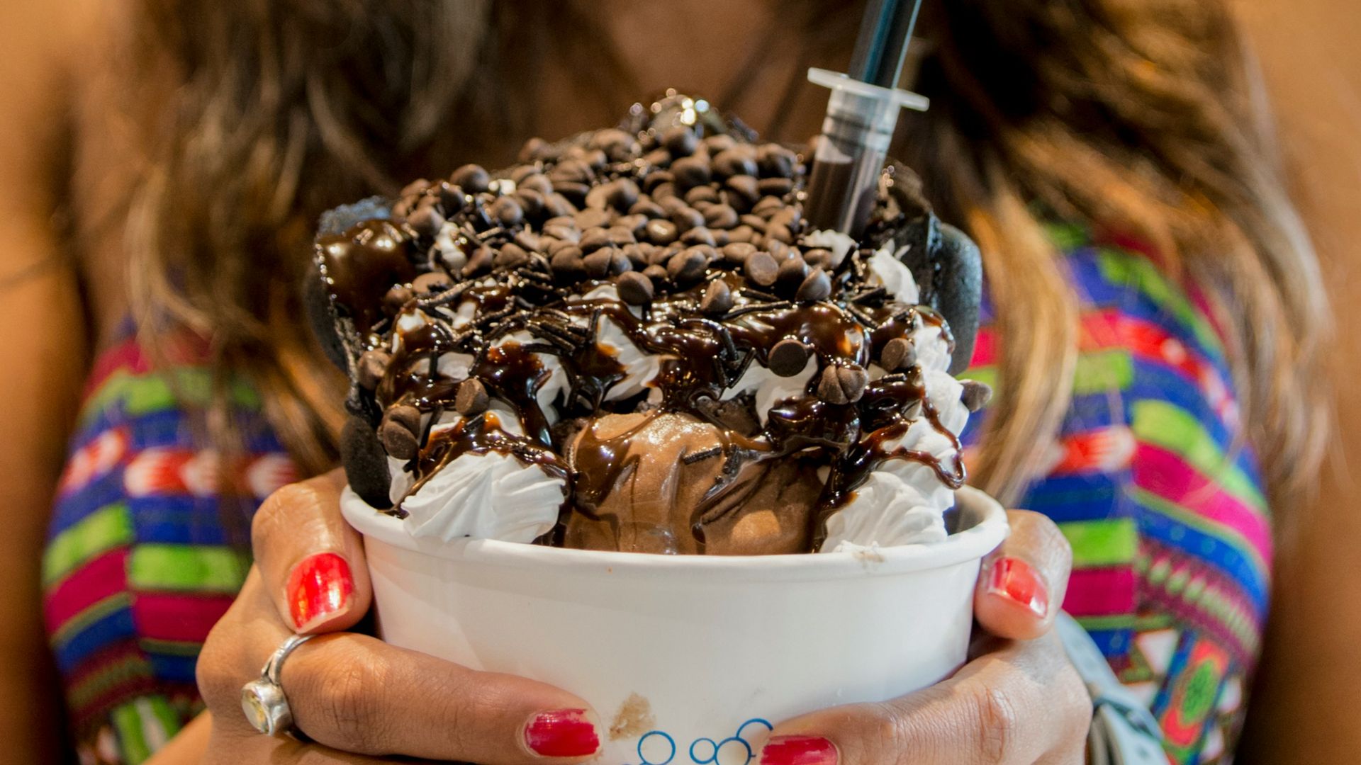 woman holding white disposable cup with ice cream