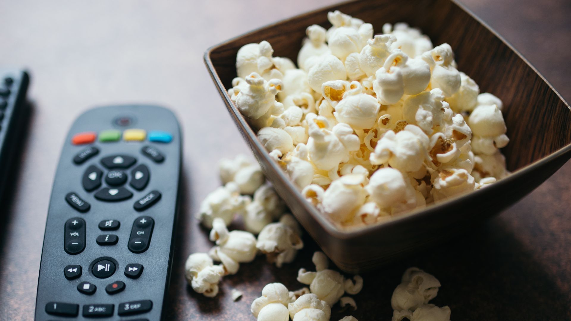 File:Remote control and popcorn on brown table closeup.jpg