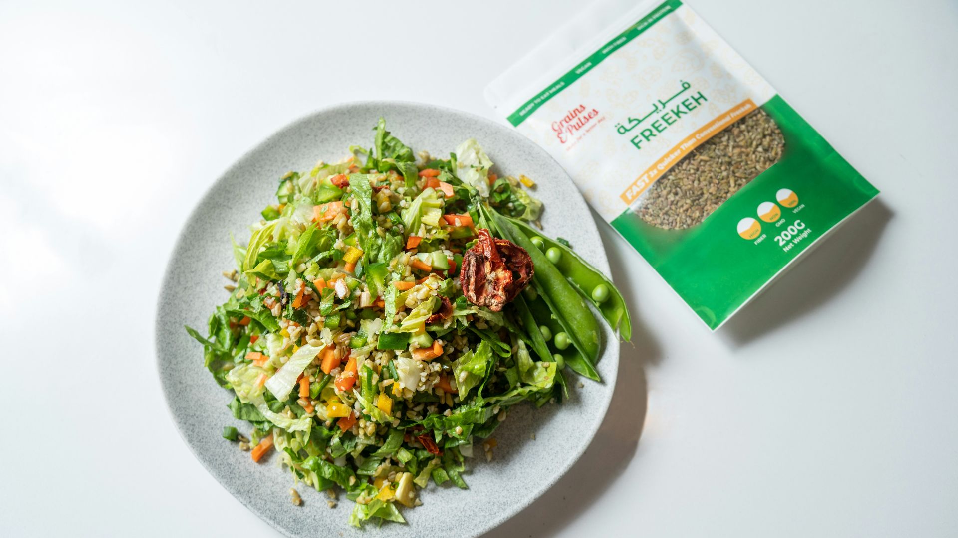 a white plate topped with a salad next to a bag of seeds