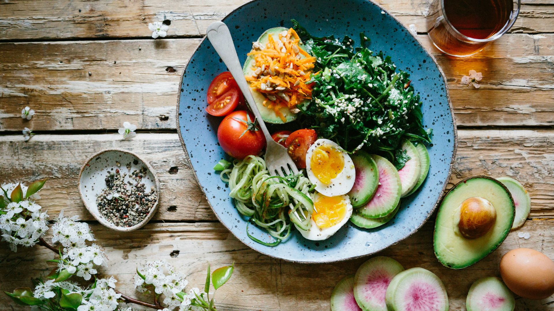 poached egg with vegetables and tomatoes on blue plate
