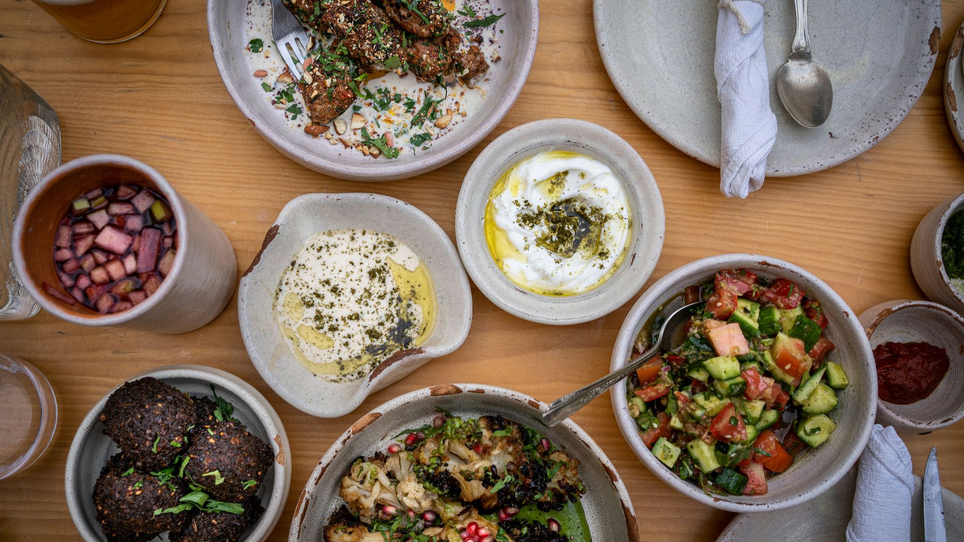 a wooden table topped with bowls of food