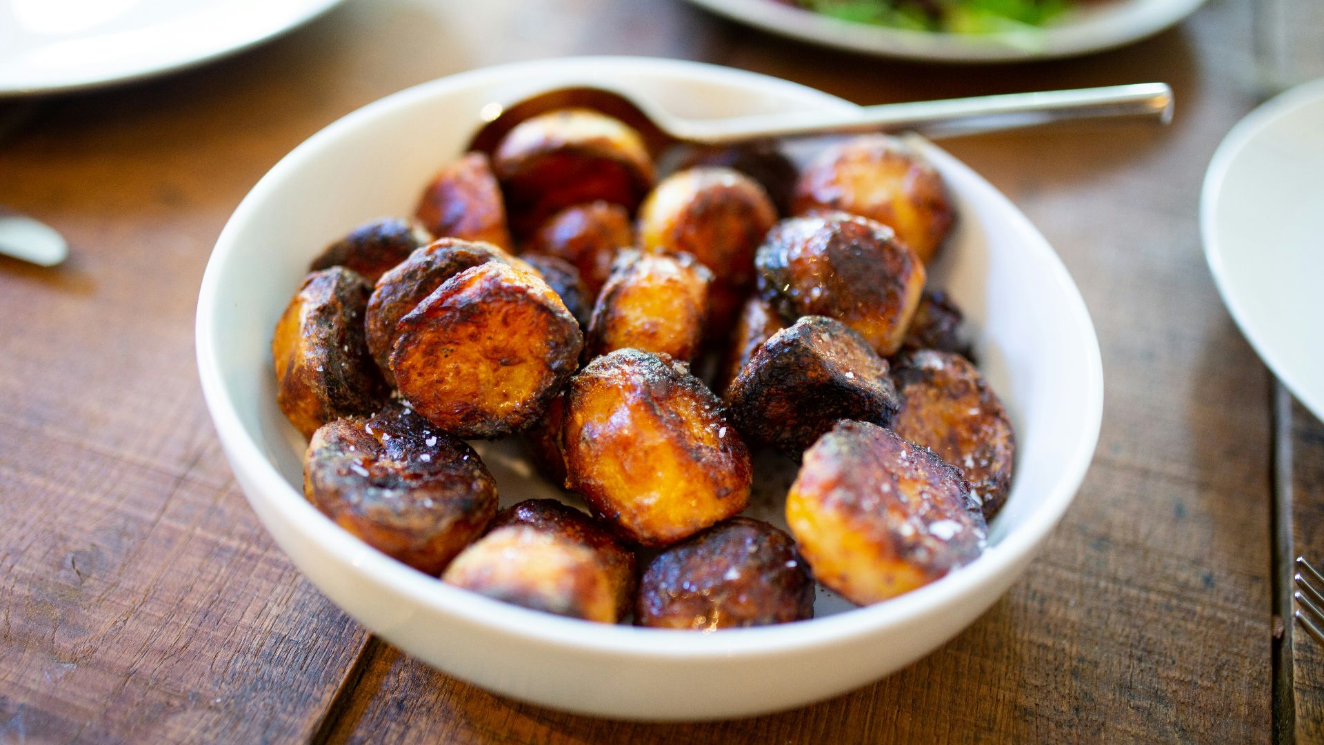 selective focus photography of glazed nuts inside white ceramic saucer