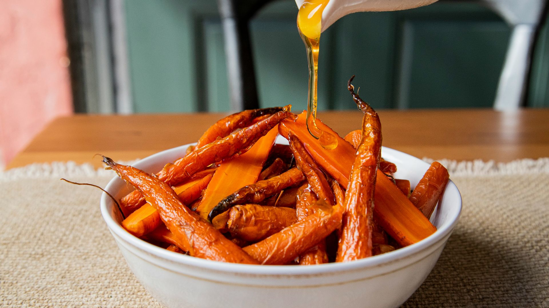 a white bowl filled with carrots sitting on top of a table