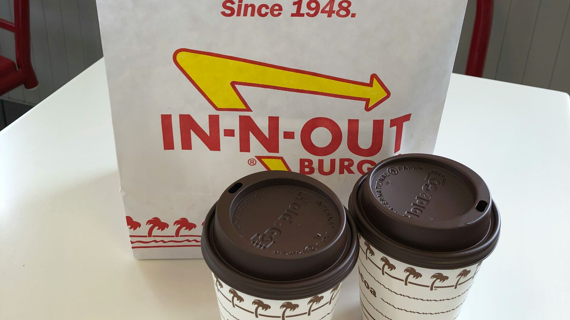 two white hot cocoa cups near white paper bag