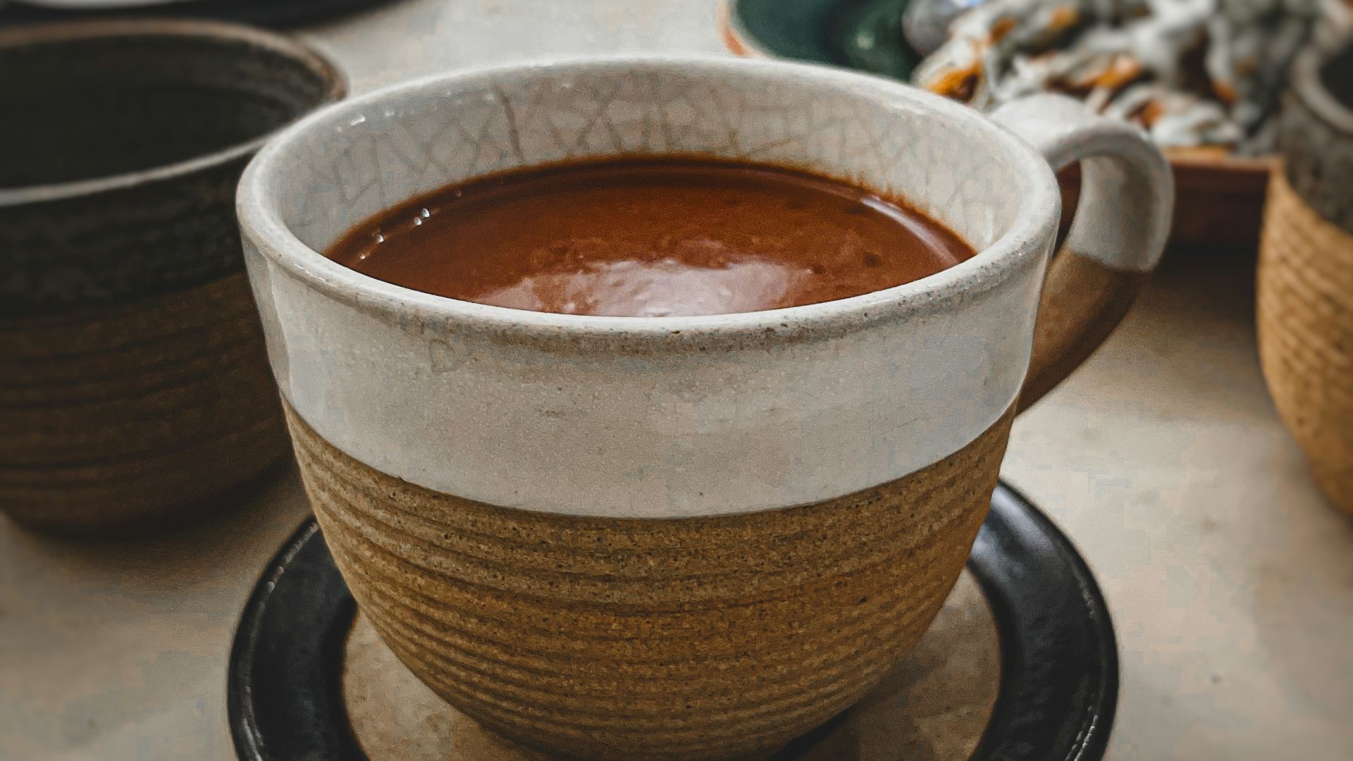 a bowl of soup sitting on top of a black plate