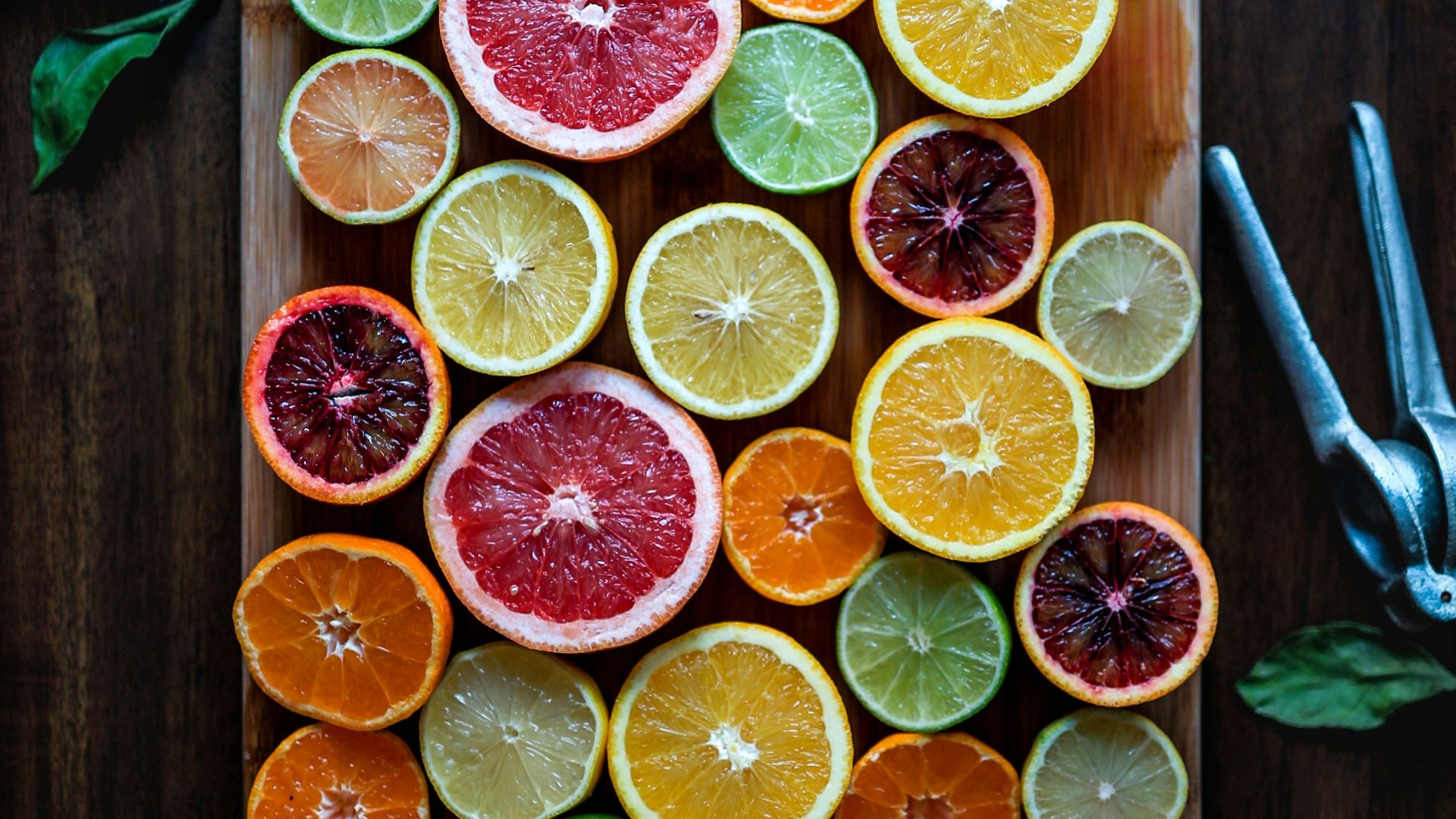 assorted sliced citrus fruits on brown wooden chopping board