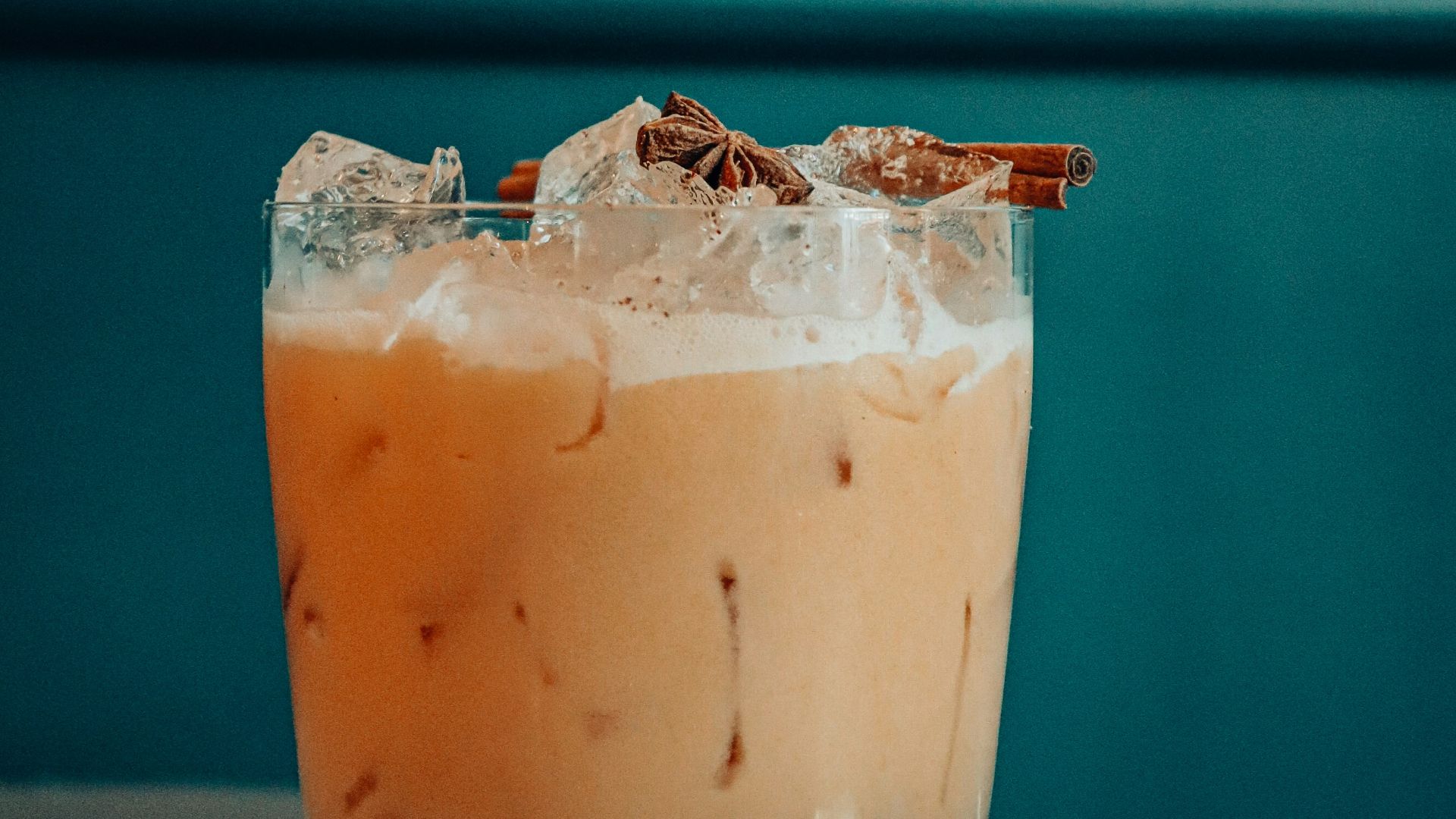 clear drinking glass with brown liquid and ice