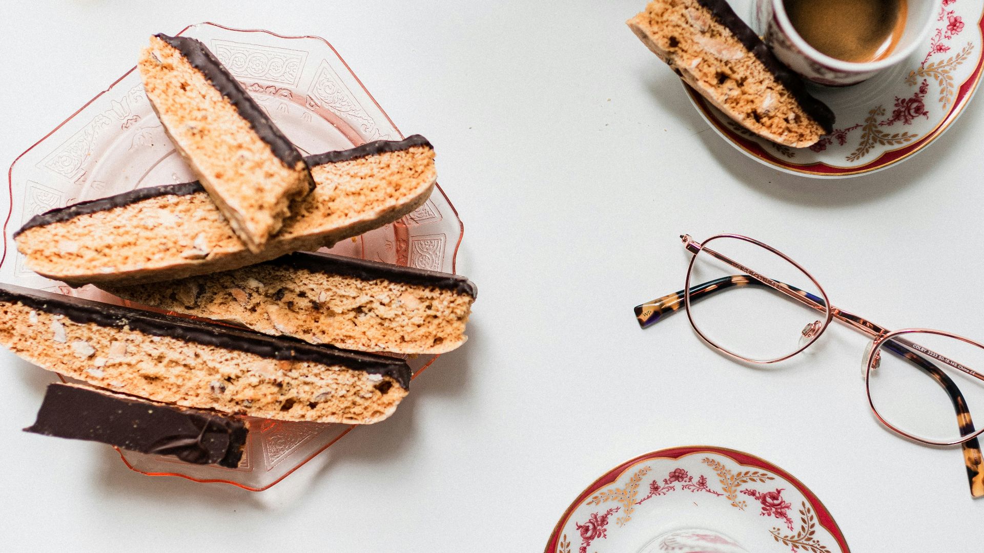 a person is holding a cup of coffee and some cookies