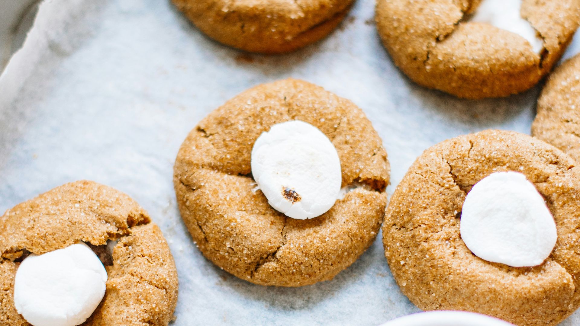 white ceramic mug with coffee beside cookies
