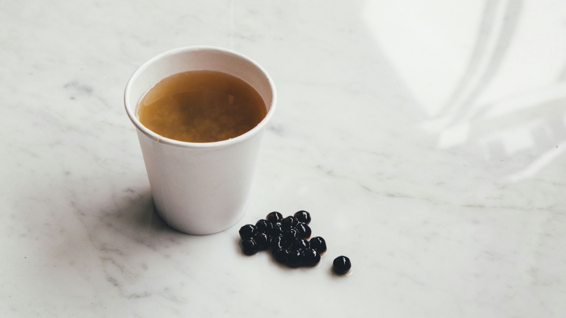 white ceramic mug beside coffee beans