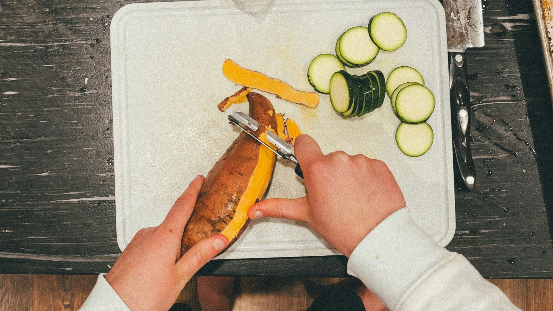 a person cutting vegetables on a cutting board