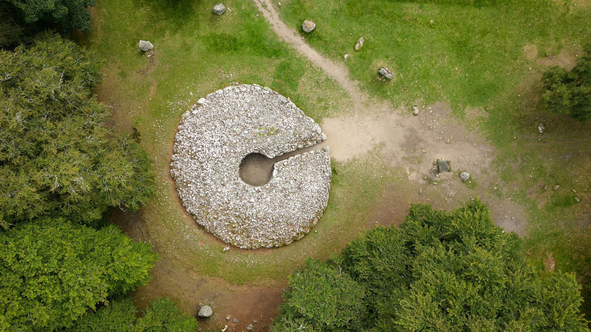 an aerial view of a large rock in the middle of a forest
