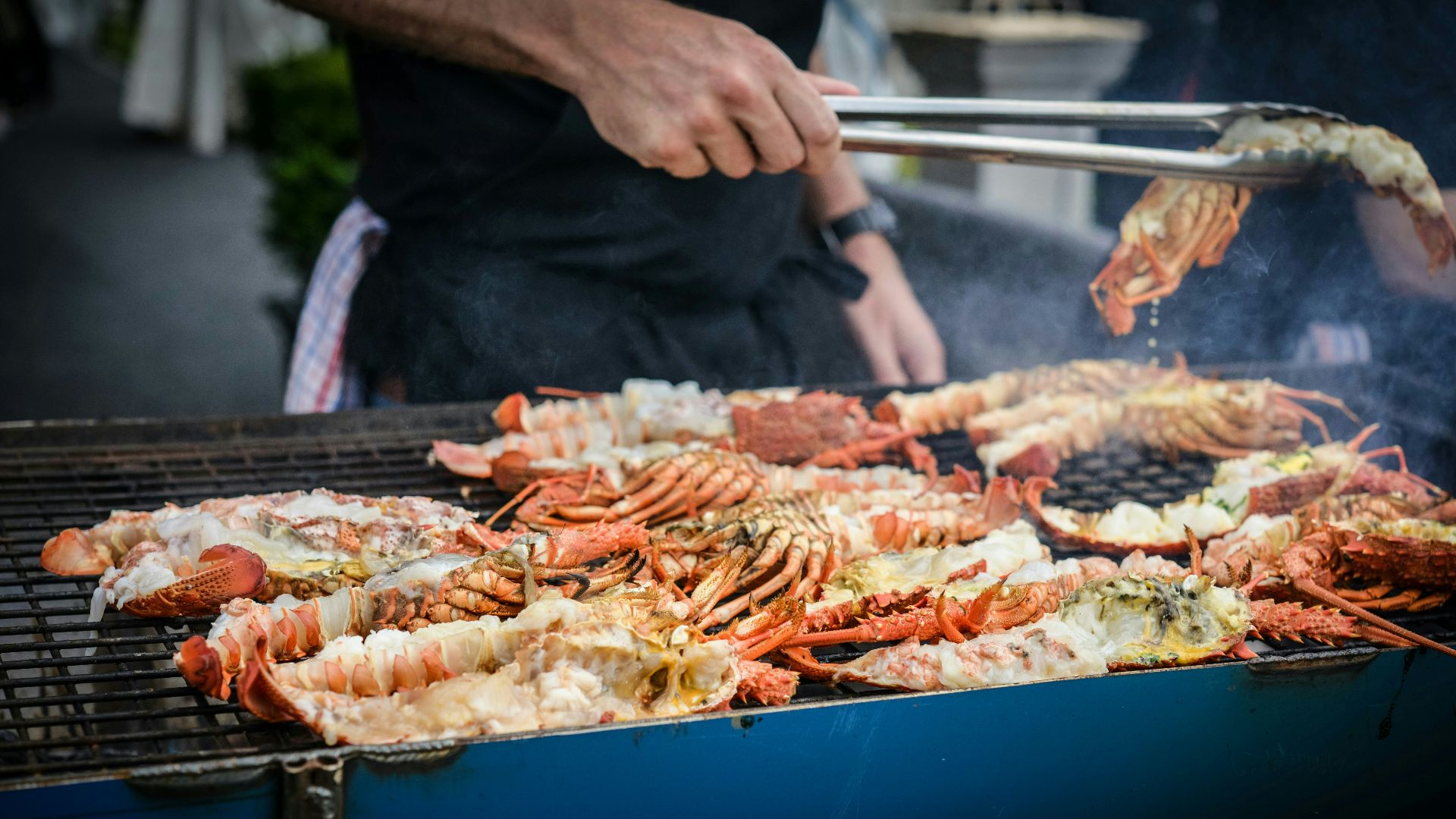 man grilling crabs during daytime