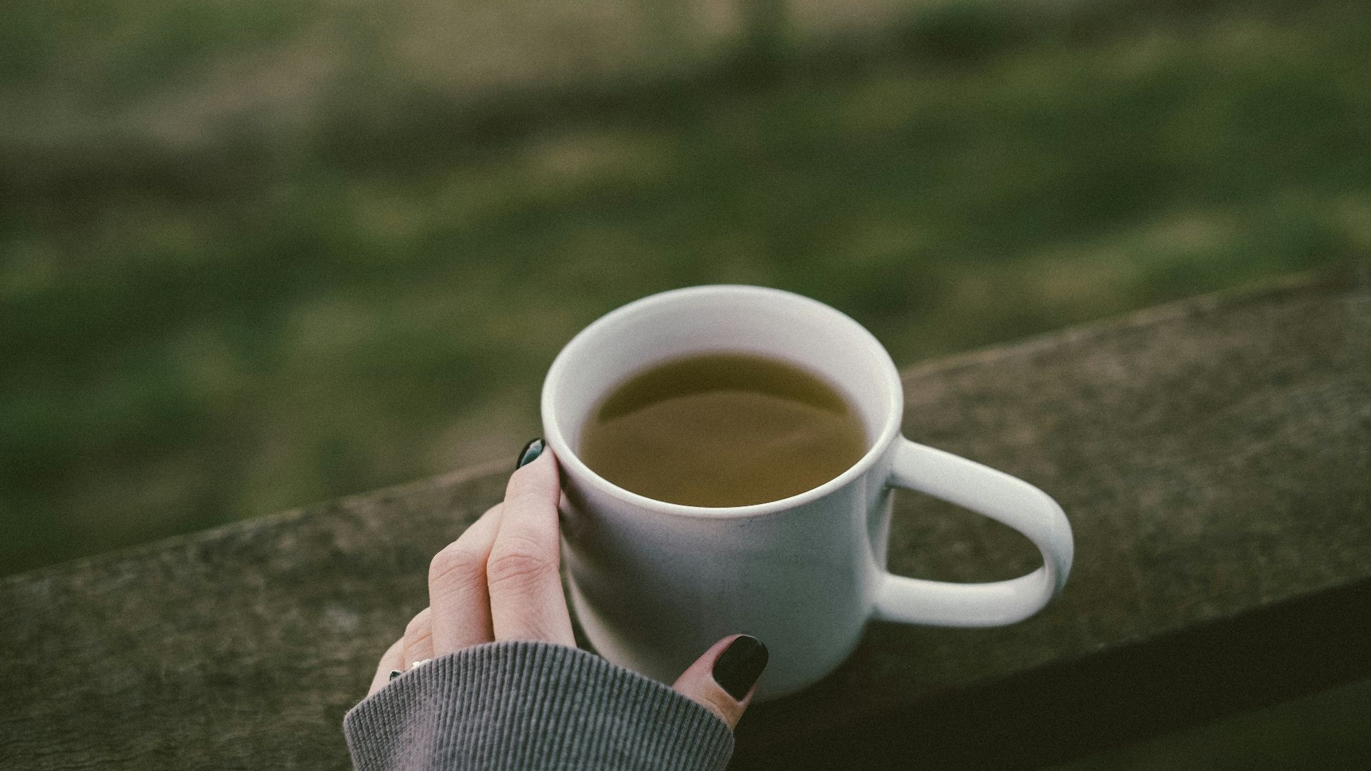 a woman's hand holding a cup of coffee