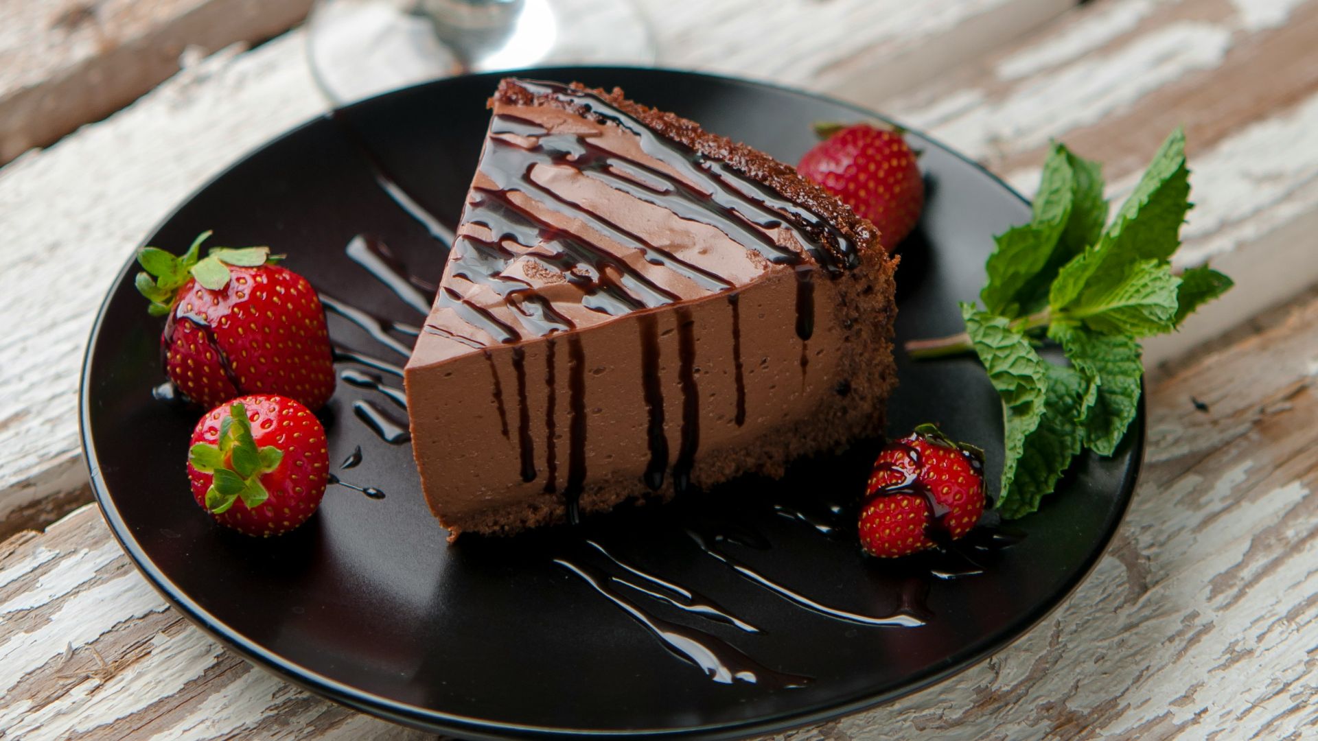 chocolate cake beside strawberries and wine glass