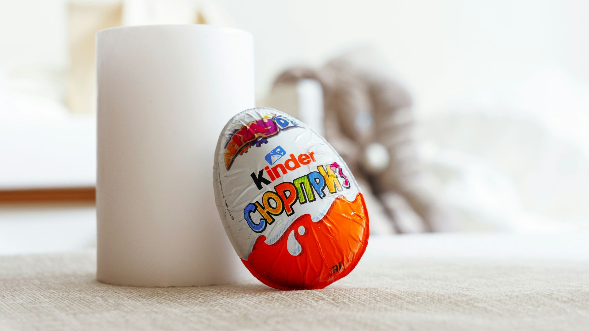 a white cup sitting next to an orange and white egg
