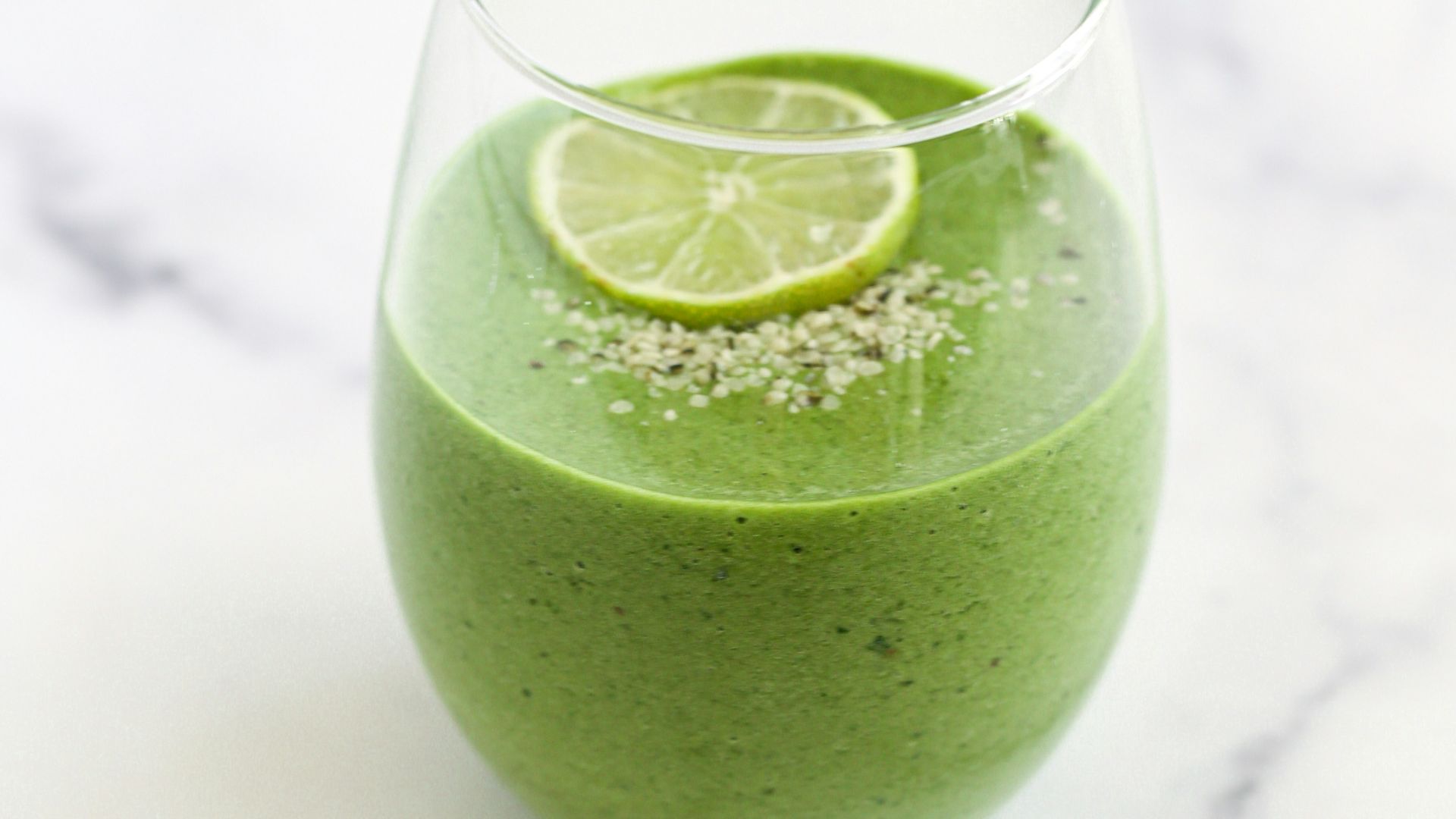 a green smoothie with a lime slice on top