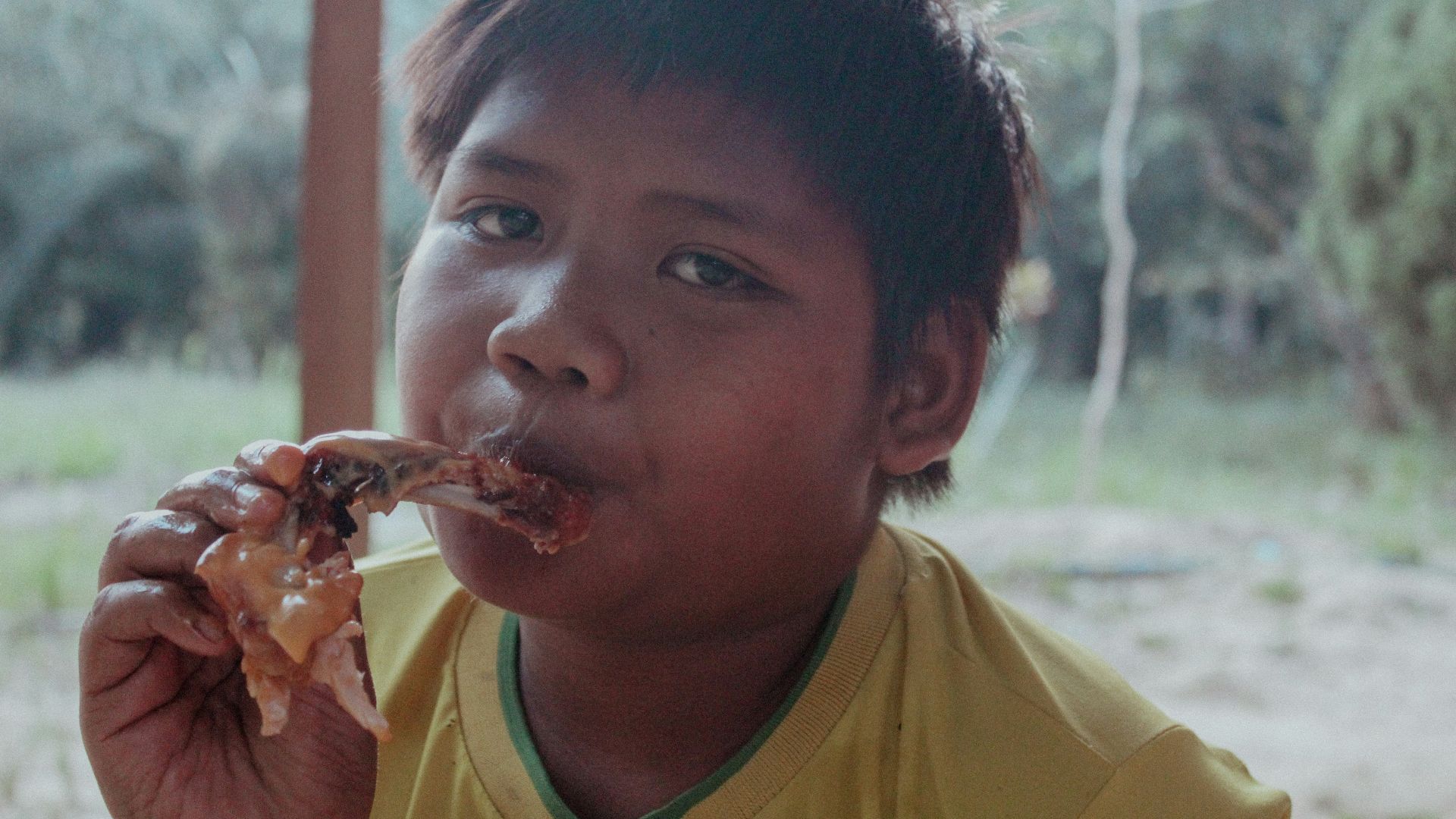 a young boy eating a piece of pizza