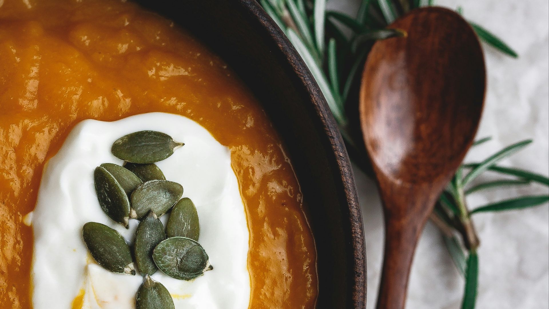 stew in round wooden bowl beside wooden spoon