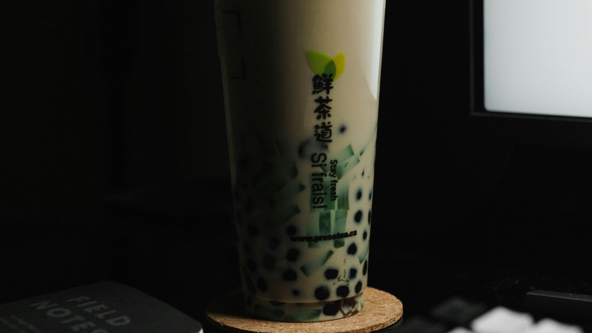 a cup of coffee sitting next to a computer keyboard