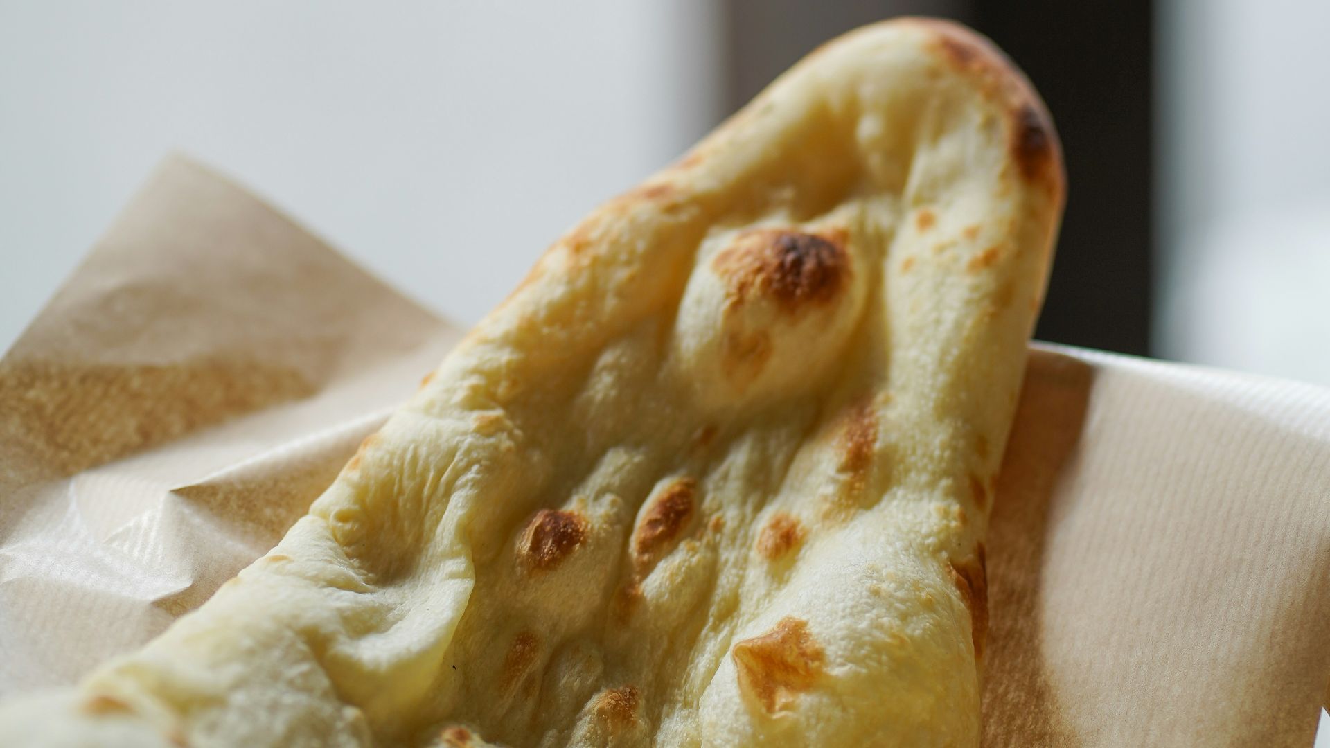 a slice of pizza sitting on top of a napkin