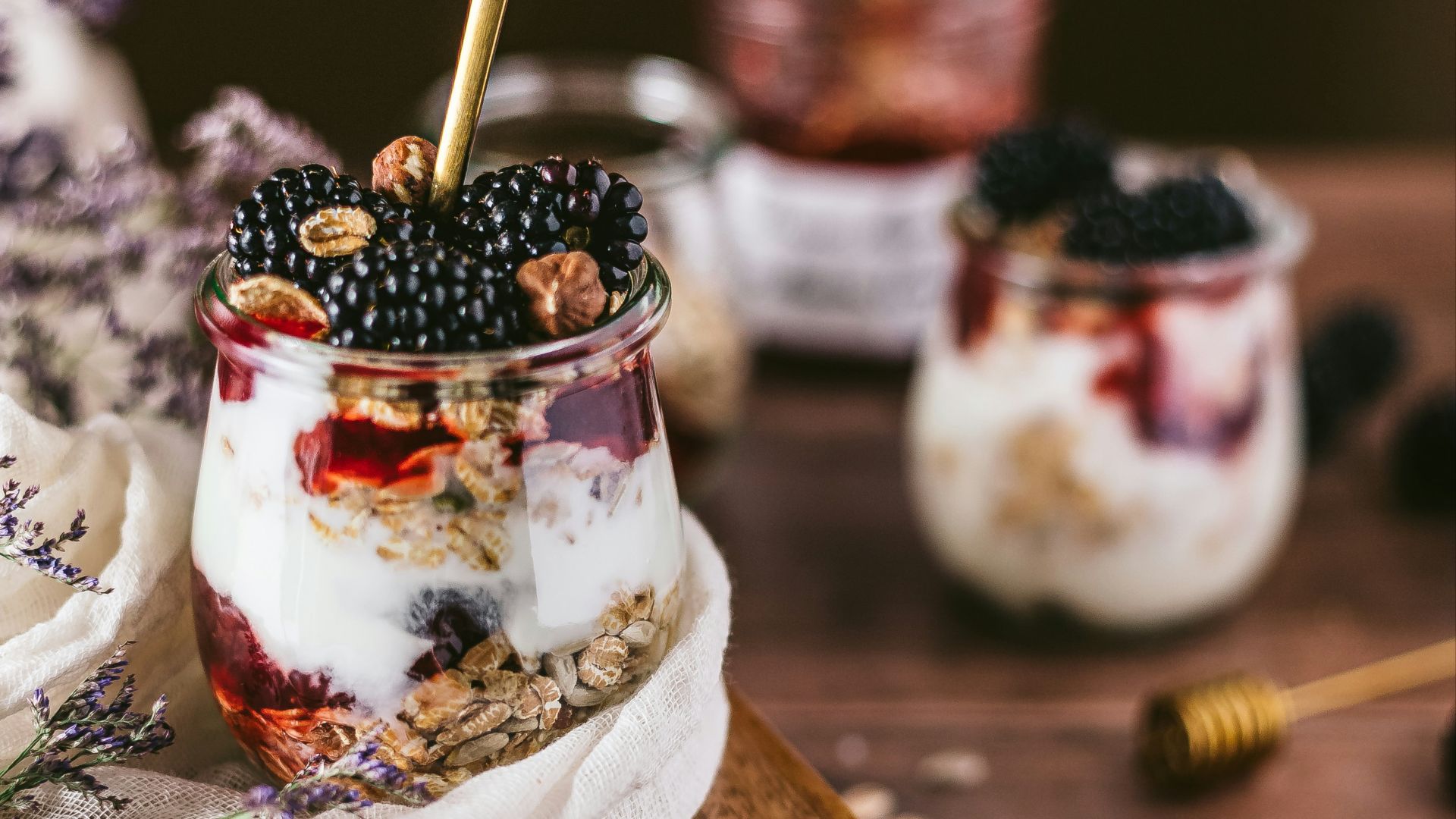 white ice cream with black berries on brown wooden table