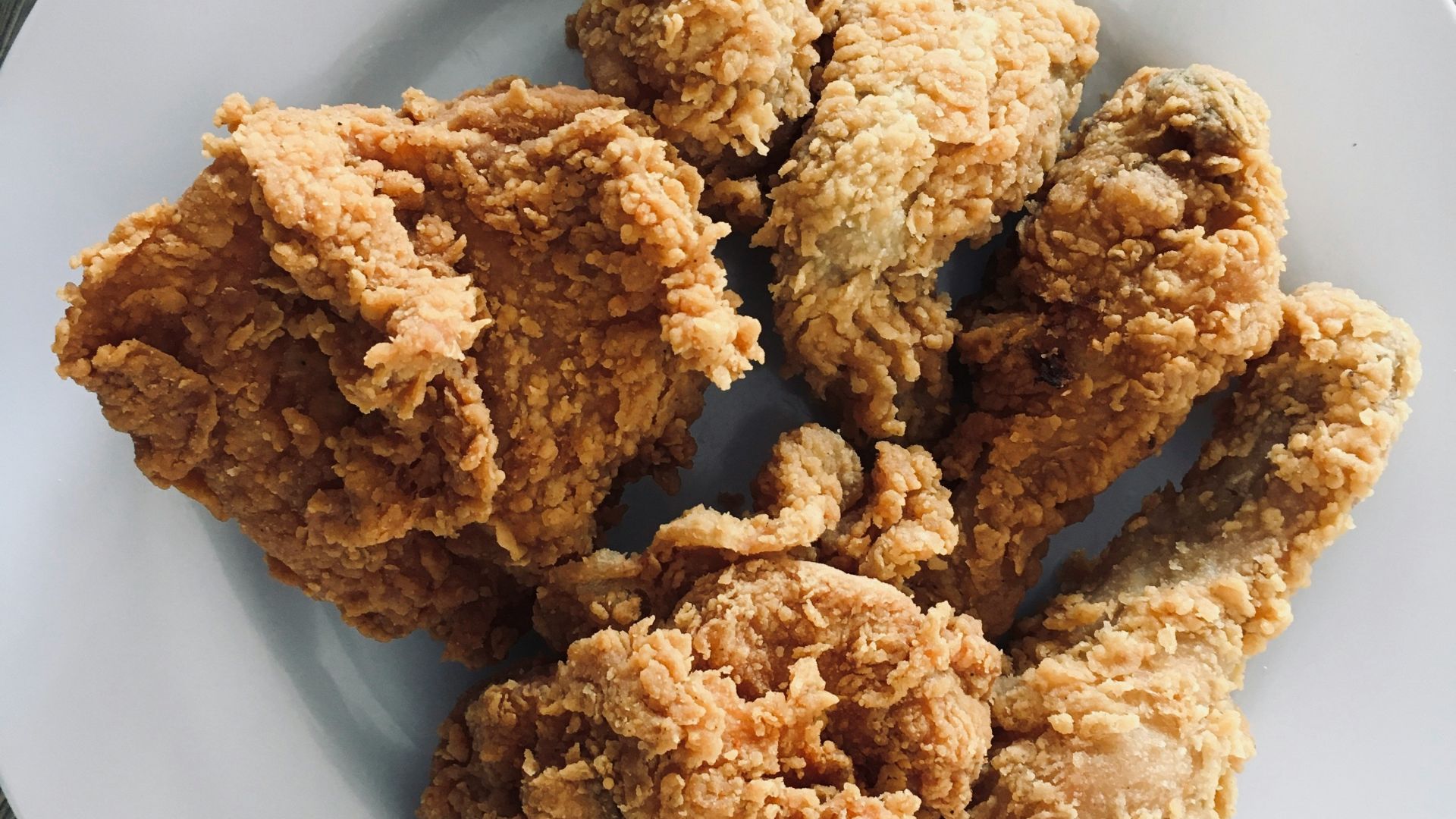 a white plate topped with fried food on top of a wooden table