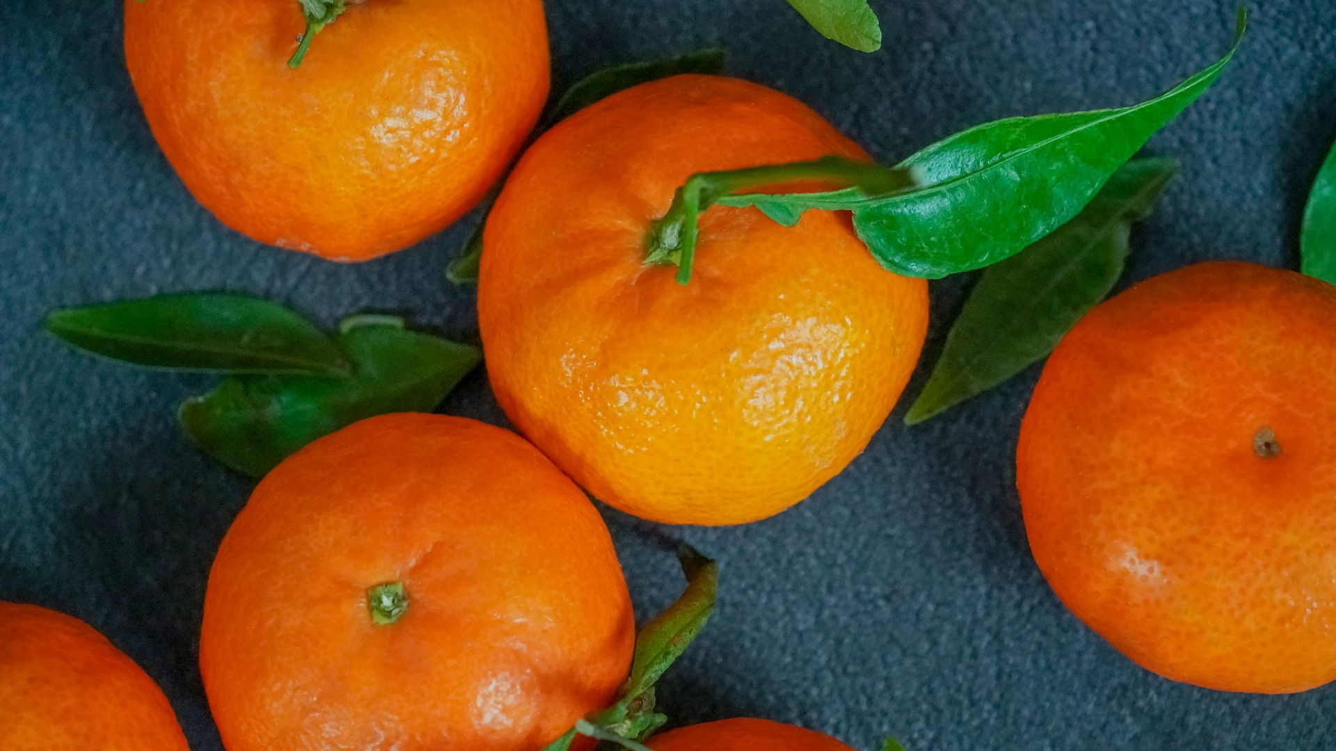 orange fruits on gray textile