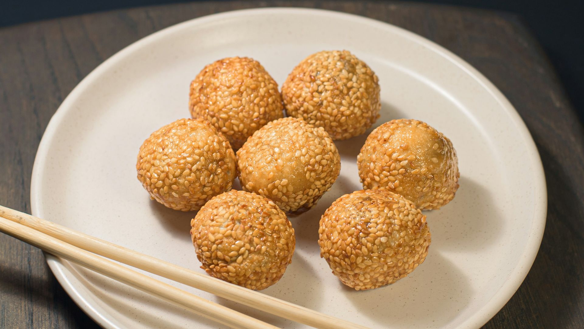 a white plate topped with meatballs and chopsticks