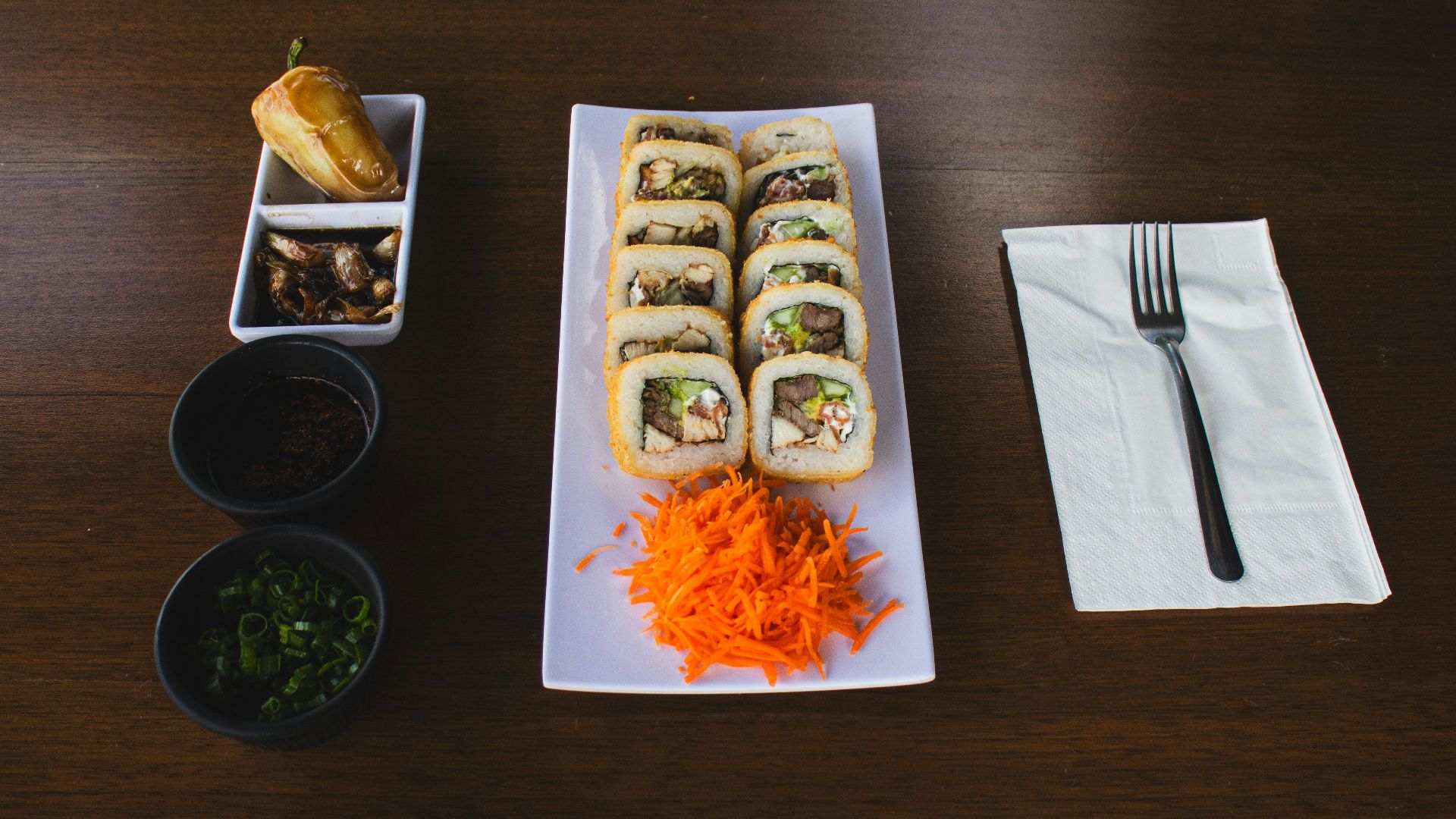 A wooden table topped with plates of food