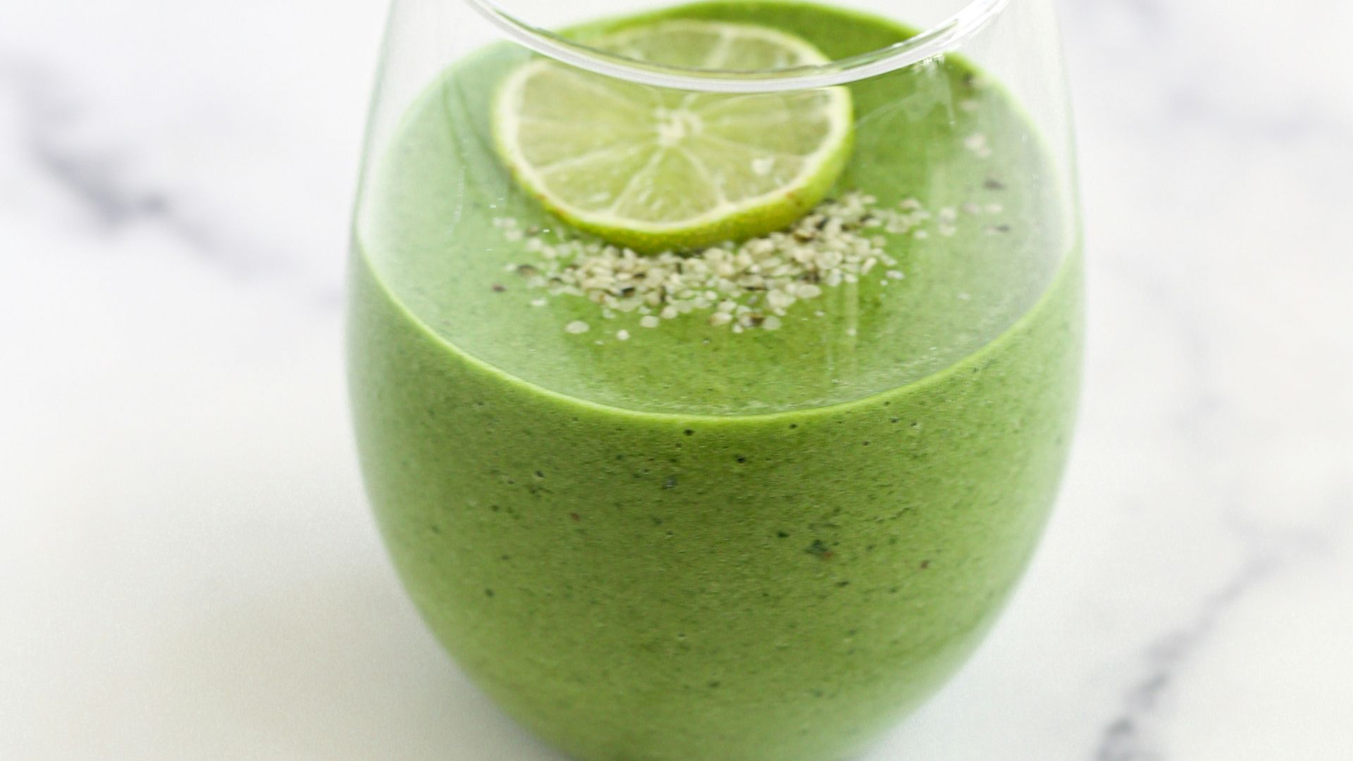 a green smoothie with a lime slice on top