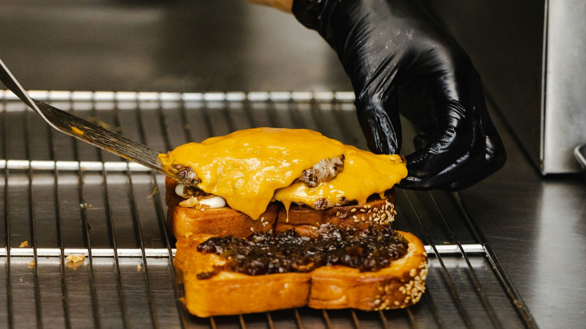 a person with a knife cutting into a sandwich