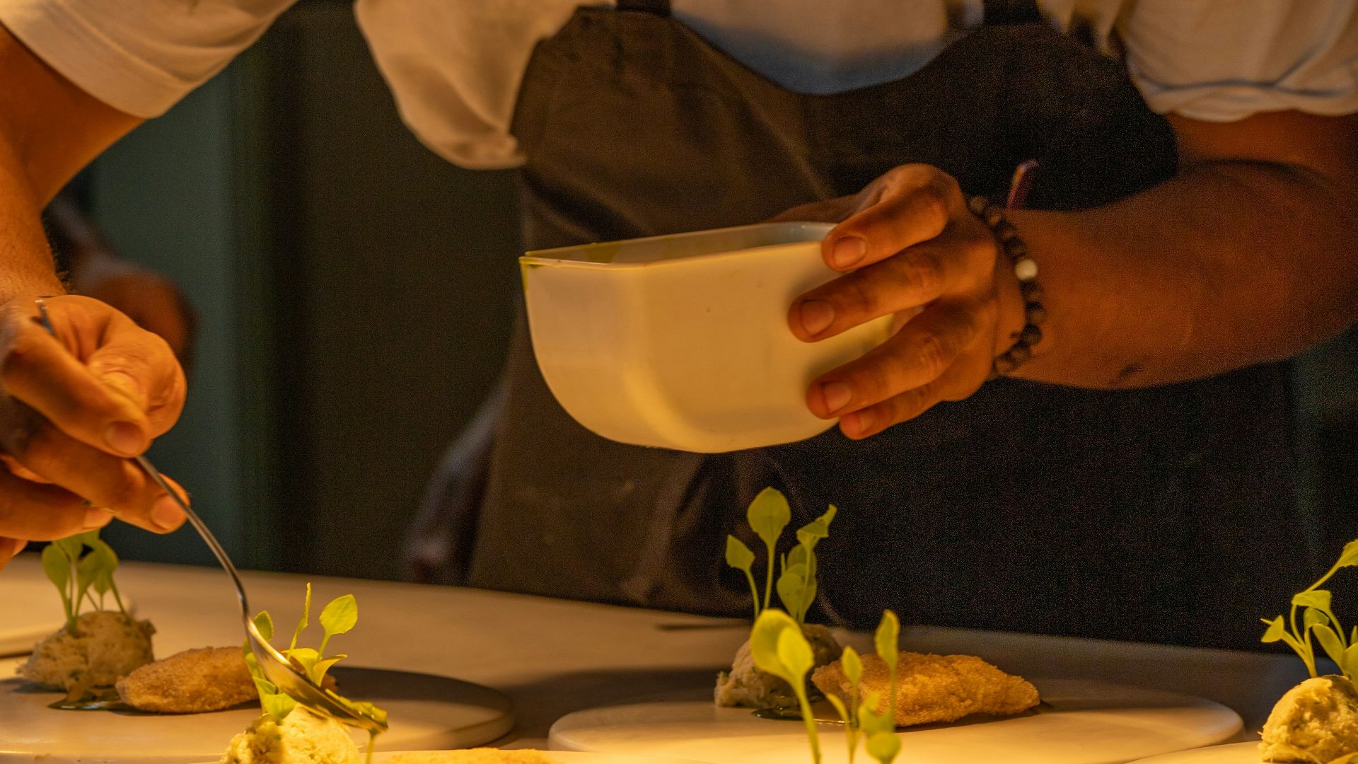 A man in a hat is preparing food on a table