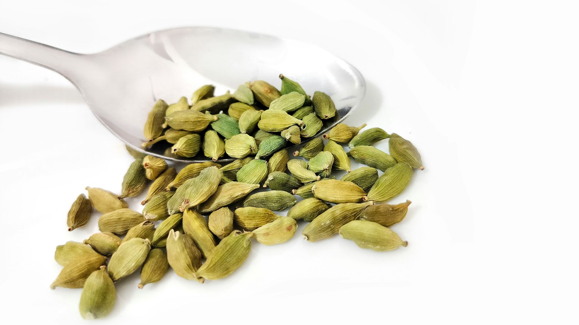 a spoon full of pistah sitting on top of a white table