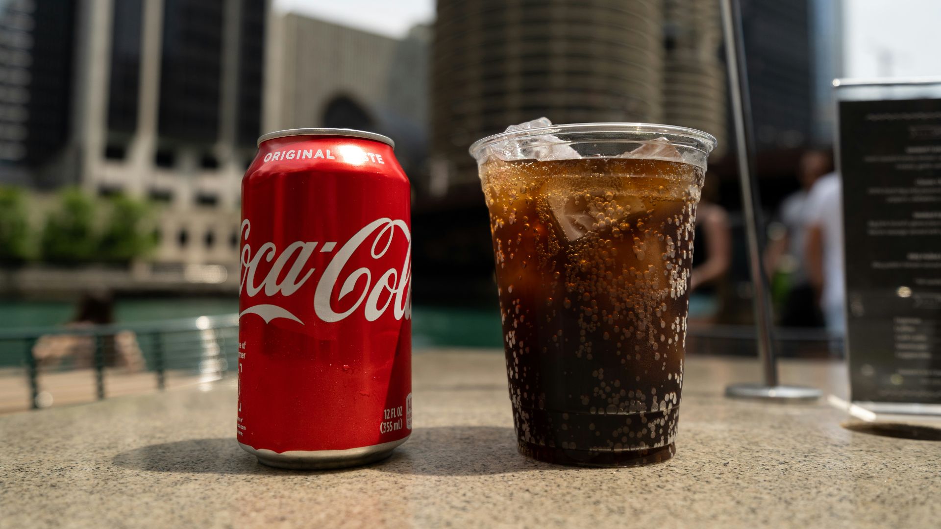 Coca-Cola soda tin can and cup on table close-up photography